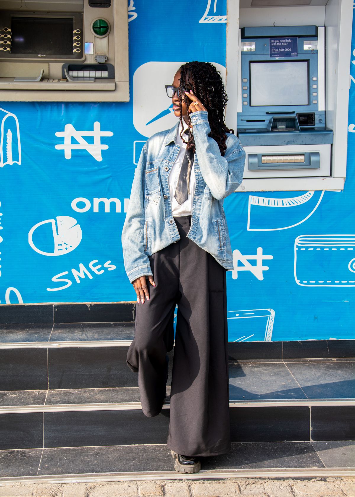 A person using a smartphone beside an ATM