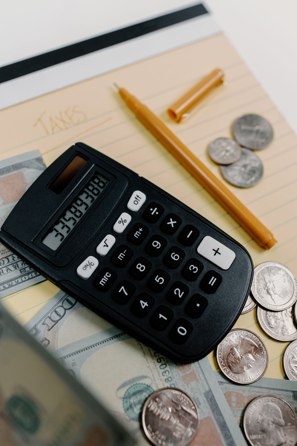 A calculator, notes and cash used for financial planning