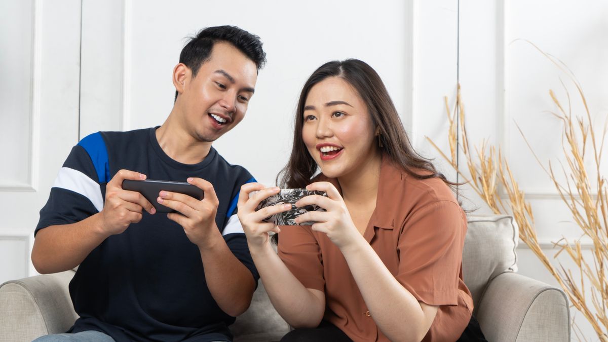 A couple using smartphones together at home