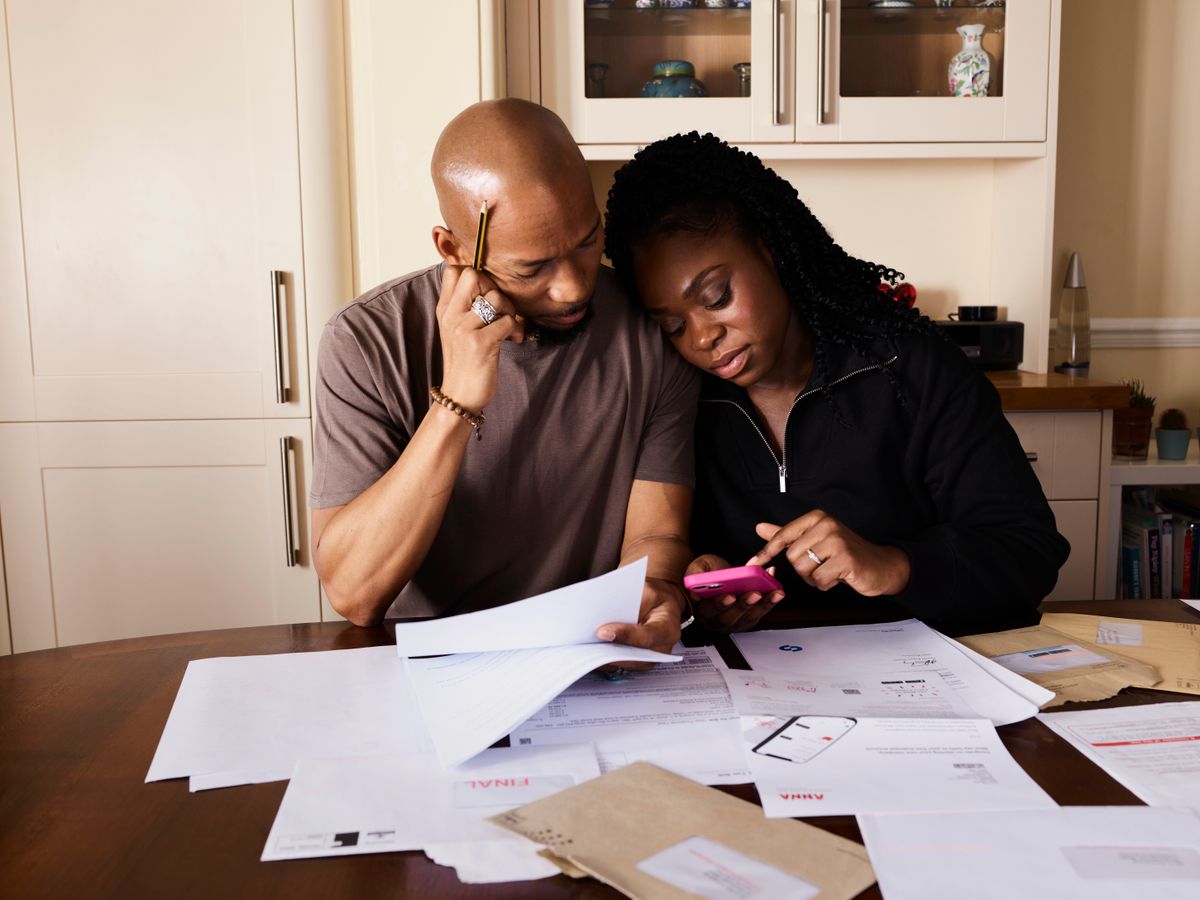 A couple checking expenses, documents and a smartphone