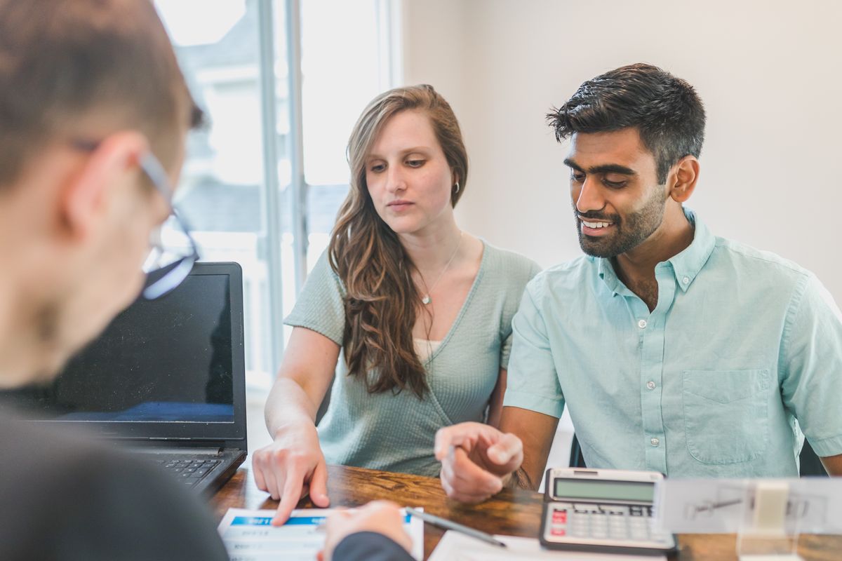 People discussing finances with documents and a calculator