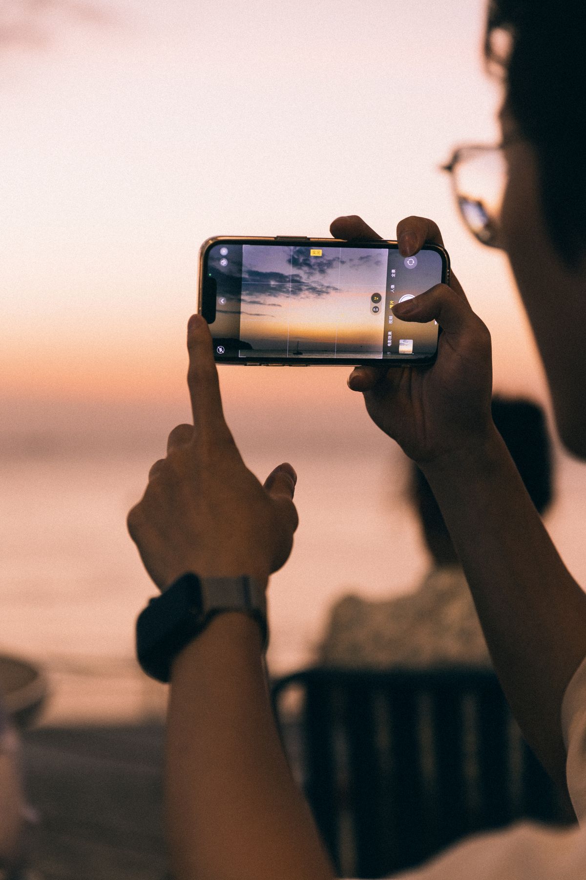 A person using a smartphone beside the sea in Langkawi