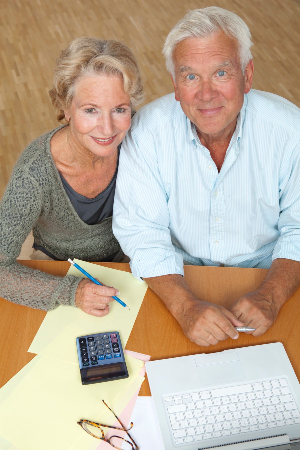 An older couple planning finances with a calculator