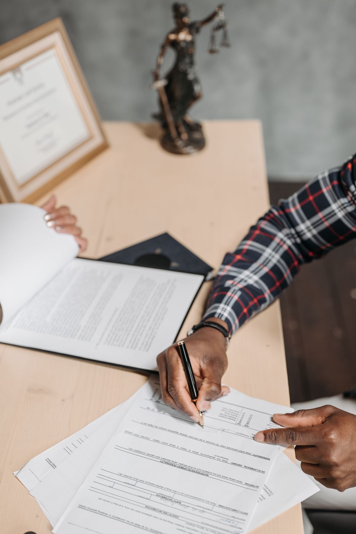 A person reviewing and signing documents at a desk