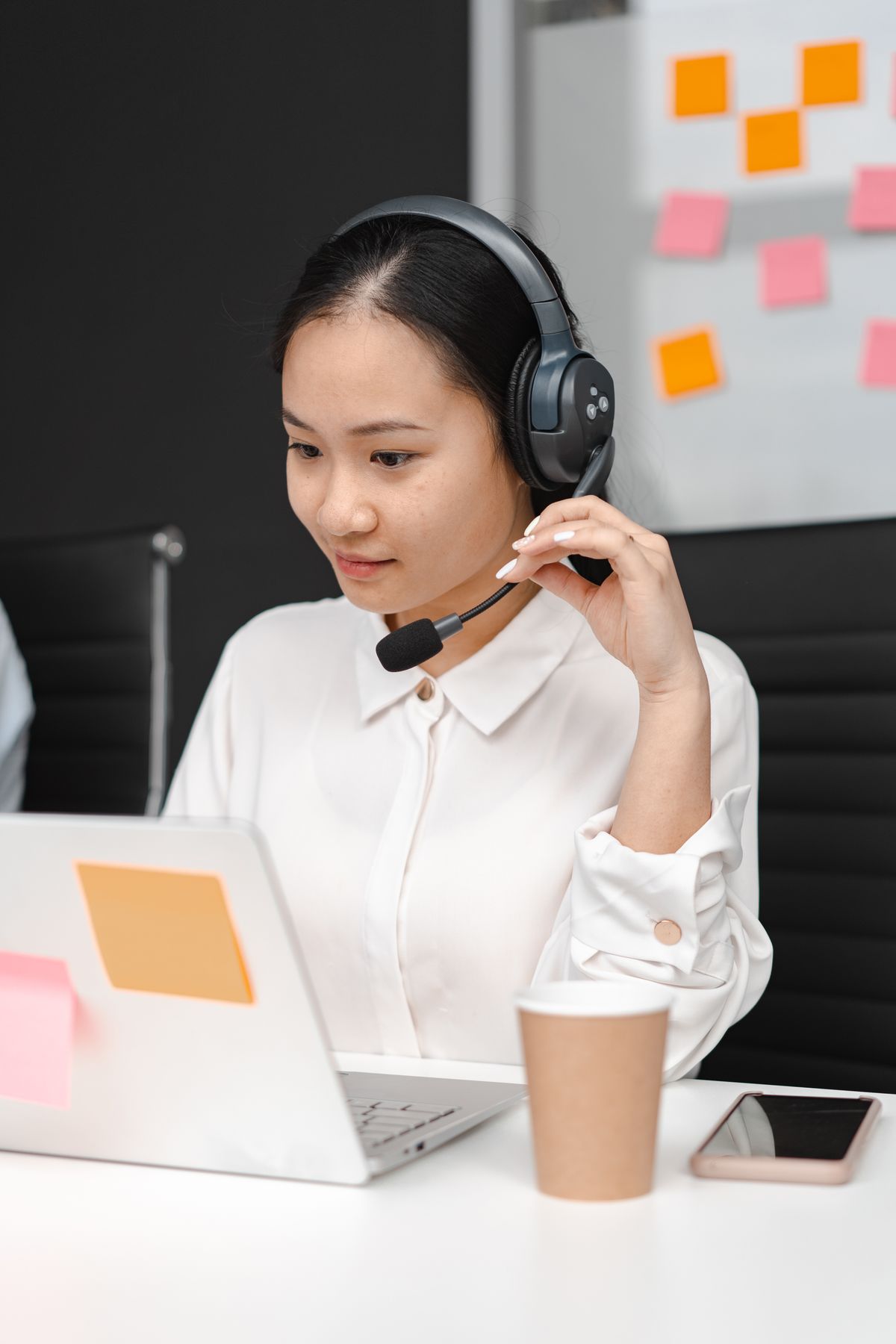 A customer support agent working with a laptop and headset